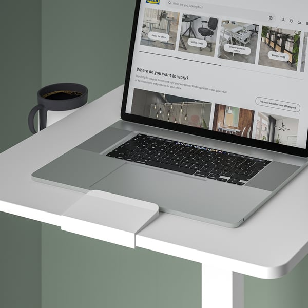 Laptop table with adjustable height, suitable for various work positions. A cup holder is visible on the left side.