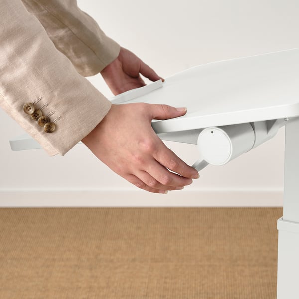 Person adjusting height of MITTZON adjustable laptop table.