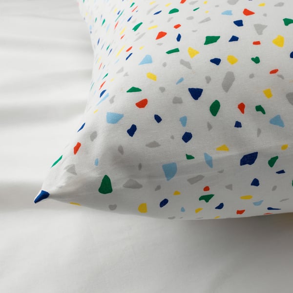 Quilted pillow cover with vibrant terrazzo-like pattern on white background. Durable cotton with colourful geometric shapes.