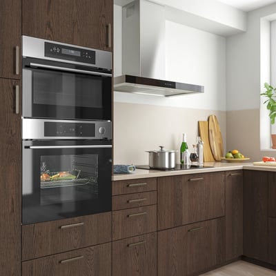 Modern kitchen with large MUTEBO oven, dark cabinets, and stainless steel handles. Countertop with cooking tools and fruits.