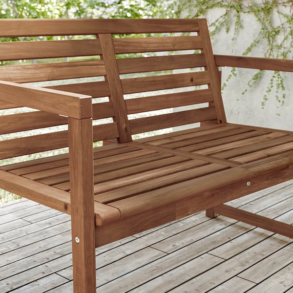 Brown wooden outdoor bench, part of IKEAs NÄMMARÖ series. Made of sturdy acacia wood with slatted design for ventilation.