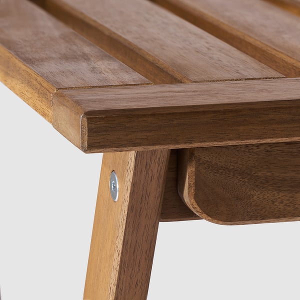 Close-up of NÄMMARÖ wooden tables edge. Made from smooth, durable acacia, it shows craftsmanship with visible wood grain and a natural finish.