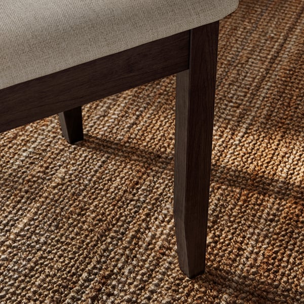 Modern chair with dark, sturdy wood legs, beige upholstered seat on textured rug.