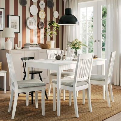 Modern dining set with white table & grey chairs, vase included.