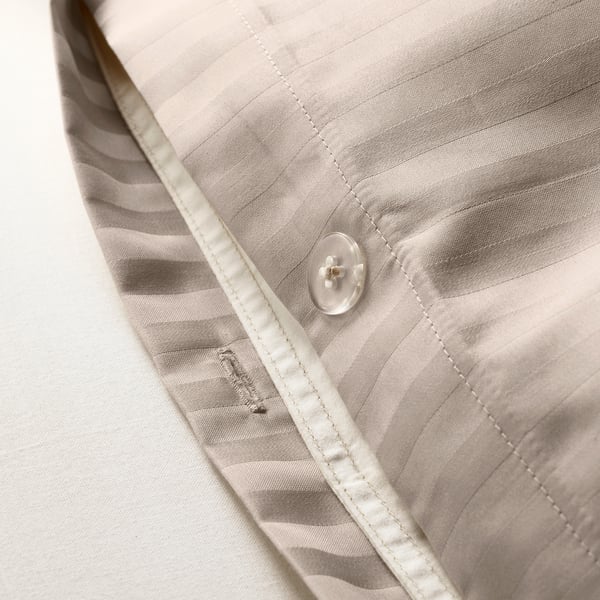 Clear button closure secures striped duvet, ensuring ease of use.