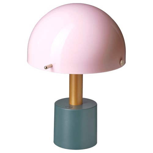 A NÖDMAST lamp with a pink shade, gold stem, and green base. Its a stylish, portable, battery-operated light.
