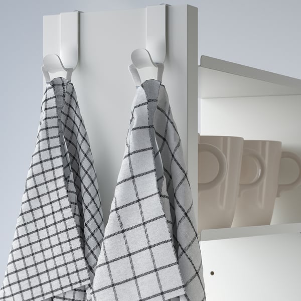 Kitchen wall unit with hooks holding grey grid towels.