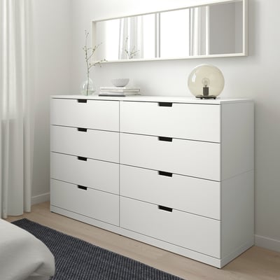 White NORDLI 6-drawer chest fits neatly beside bed, with mirror above, lamp, and decor on top.
