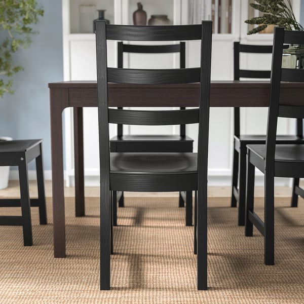 Dark wood dining chairs with ladder backs surrounding a table, designed for comfort with deep seats and high backrests.