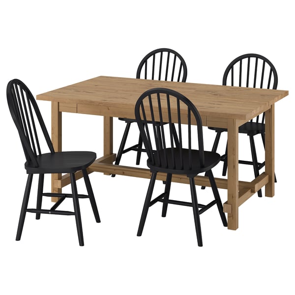 The NORDVIKEN dining set. It includes a light brown extendable table surrounded by four black chairs with spindle backs and seats.