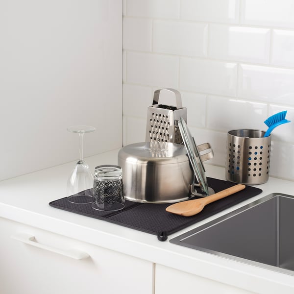 Kitchen counter with drying mat and kitchen items.