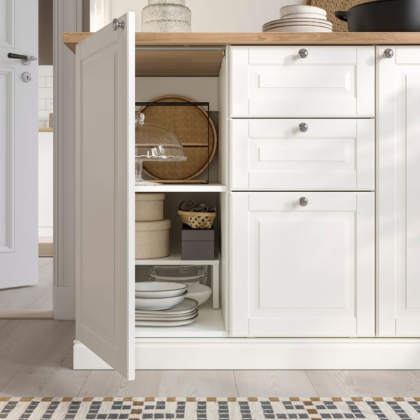Kitchen cabinet with open shelves for plates and woven baskets, closed storage with drawers and adjustable shelves.