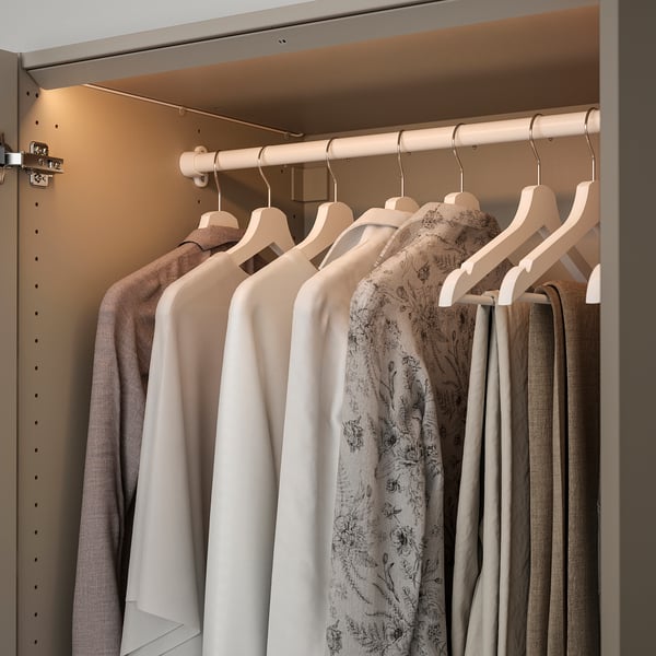 Closet with led light, clothes on hangers.