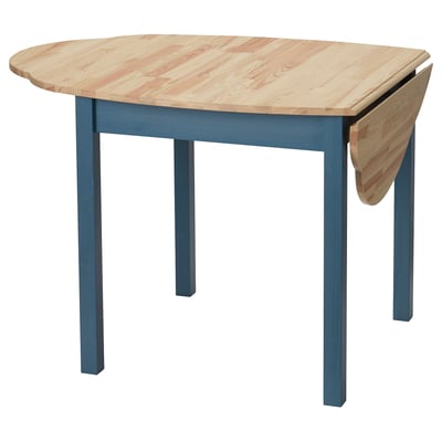 An OMMJÄNGE drop-leaf table with blue legs made of solid pine wood, offering a functional and stylish design for small spaces.