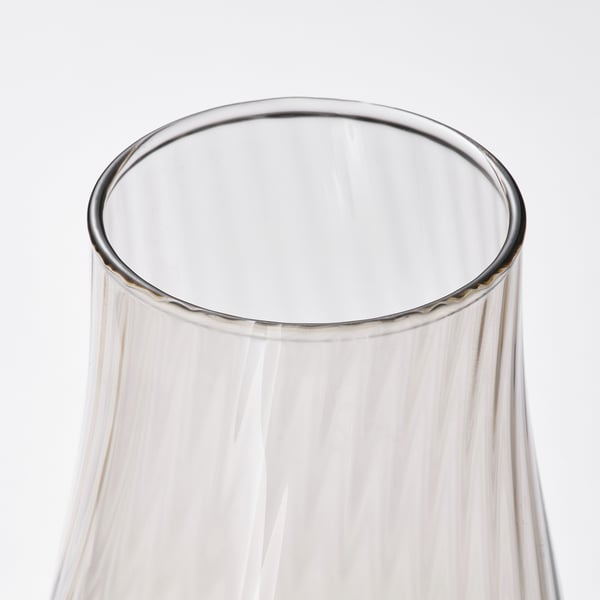 Clear glass vase with swirling patterns inside, capturing light and showcasing elegant, reflective beauty.