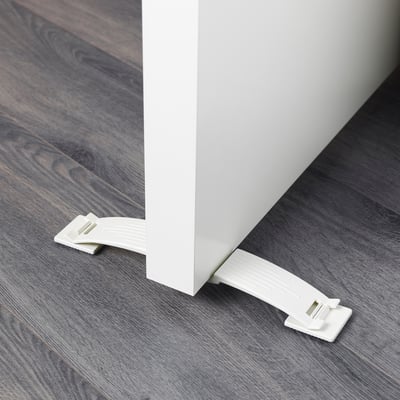 A white door stop securely attached to both sides of a door. It prevents the door from slamming shut, ensuring safety, especially for children.