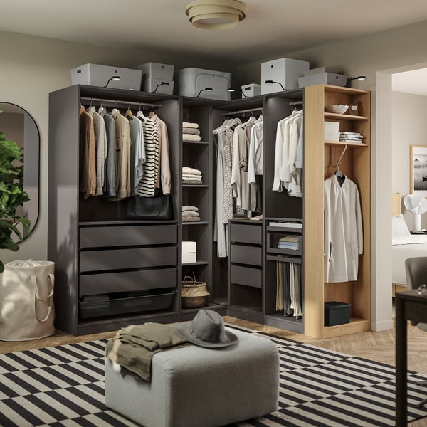 A modern walk-in closet with hanging clothes, shelves, and storage boxes. Includes drawers and hanging areas, useful for organising wardrobe items.