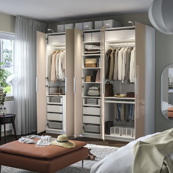 Open wardrobe with clothes, shelves, and drawers, showcasing organised attire and accessories in a bedroom setting.