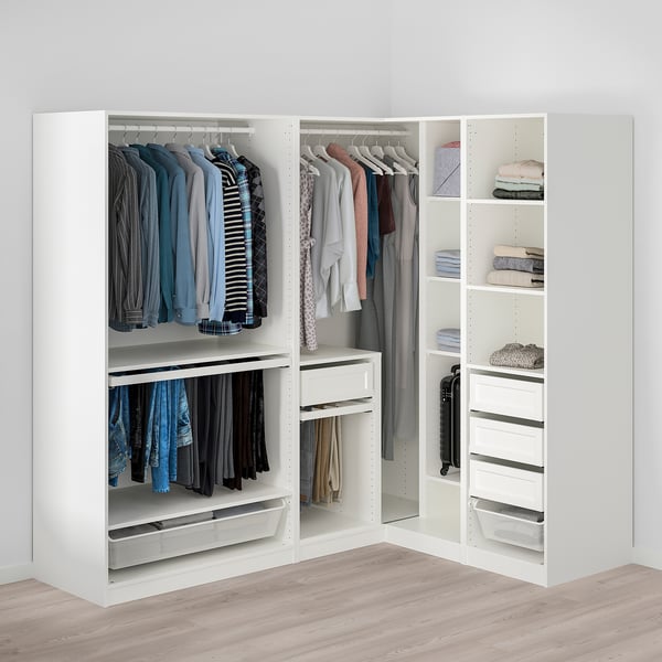 Modern corner wardrobe with open hanging clothes, shelves with folded sweaters, and mesh storage bins.