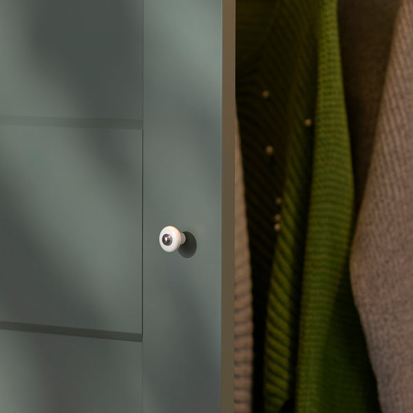 Close-up of modern, sleek wardrobe in soft green. Stylish, round handle, indicating quality finish.