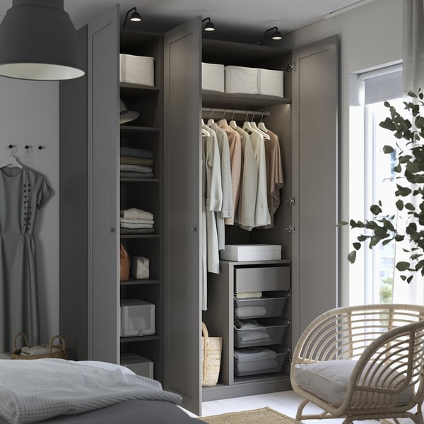 Modern bedroom with open wardrobe; hangers, shelves, and drawers organised with folded clothes, accessories, and baskets.