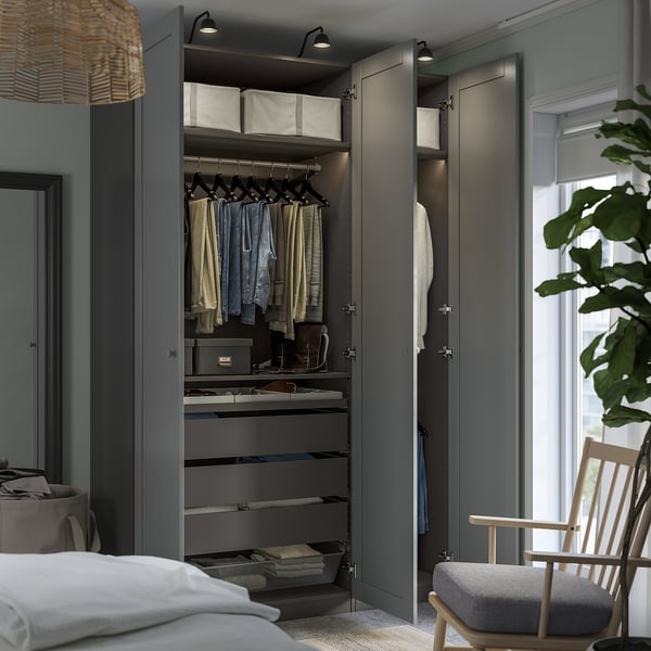 Modern bedroom with open wardrobe, lighting, and organized clothes.