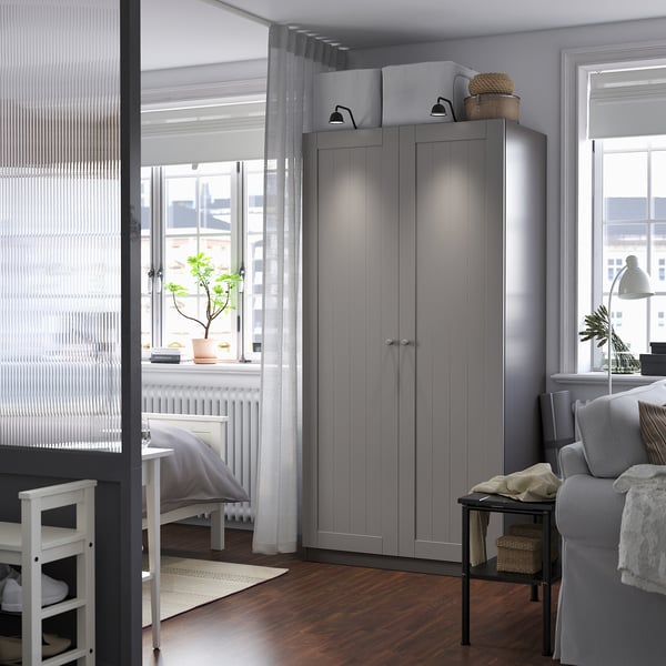 Modern grey PAX wardrobe, corner-fit, smooth panels, taller than sofa/chair.