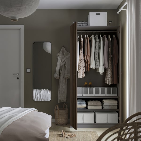 Modern bedroom with open wardrobe, hangers, storage boxes, and mirror.