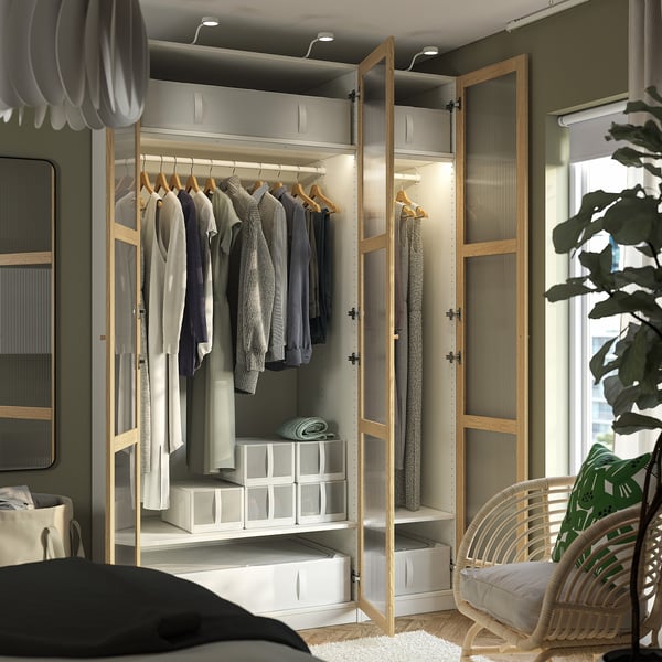 Modern open closet with clothes, featuring adjustable shelves and integrated lighting.