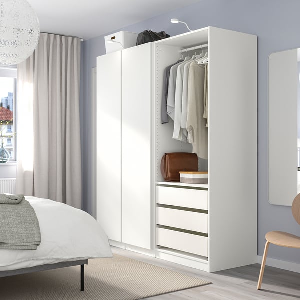 Modern bedroom with white PAX wardrobe, grey walls, and wooden chair. Large wardrobe next to bed and big window.