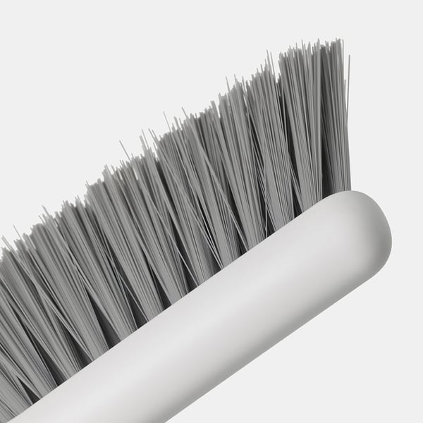 Close-up of a brush with dense, grey bristles attached to a smooth, white cylindrical handle, showcasing its quality and design.