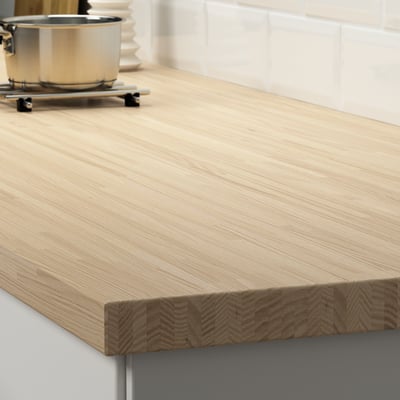 A sleek, wooden kitchen countertop, displayed with pots, showcasing its durable, sandable surface.