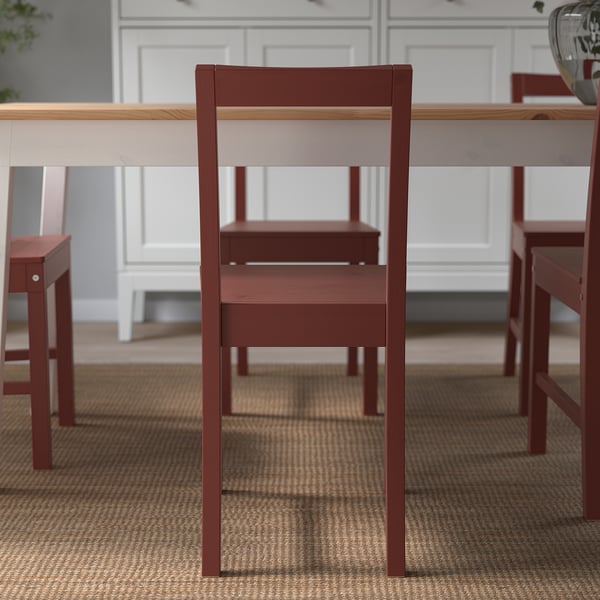 Red wooden chair with angled back, part of PINNTORP series, designed for comfort and traditional swedish style.