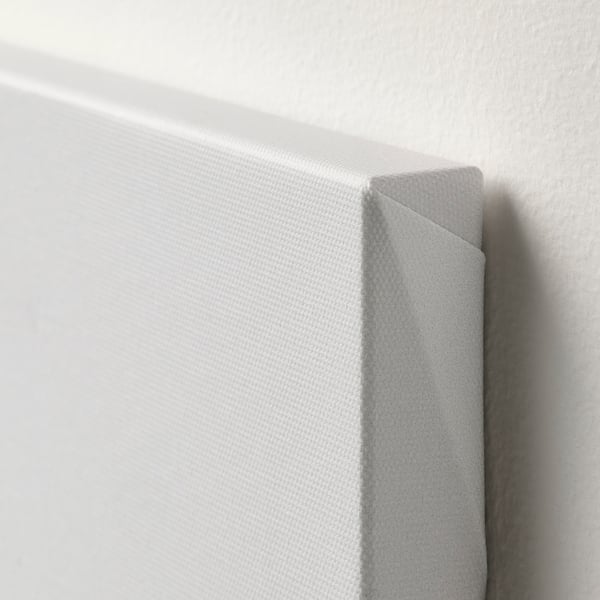 Corner of a white framed art print. Frame slightly tilted, showing off texture and quality.