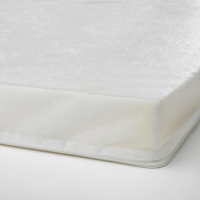 Close-up of a neatly made, white foam mattress with smooth fabric and visible stitching on edges.
