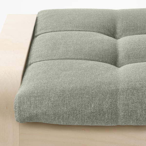 Close-up of a plush, light green textured fabric footstool, showcasing its comfortable, layered design.