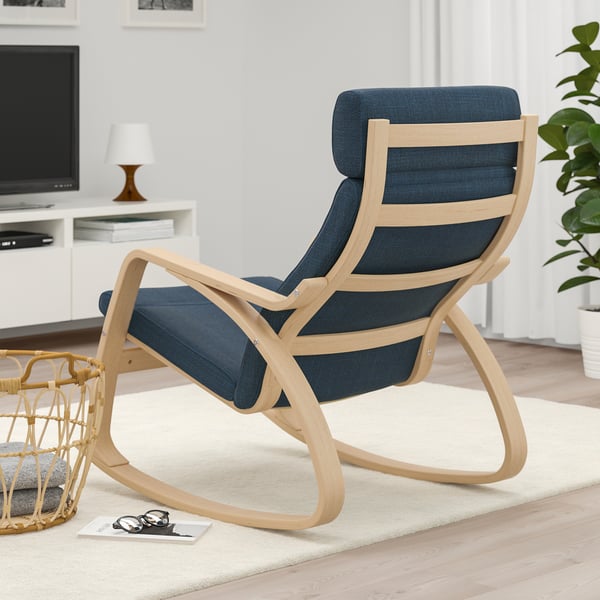 Comfortable blue cushioned rocking chair with wooden frame in living room.