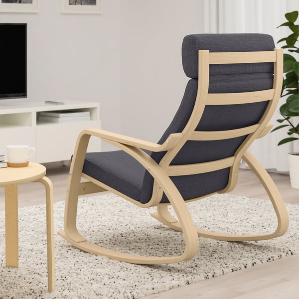 Image a comfortable POÄNG rocking armchair with a light wooden frame and dark cushions, providing resilient support and relaxation.