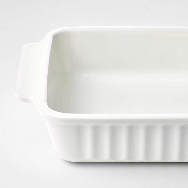 White baking dish with ribbed base and side handles, made of durable stoneware.