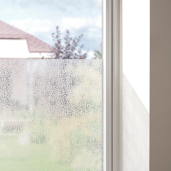 Frosted window film providing privacy, installed on a window, allowing light while obscuring views.