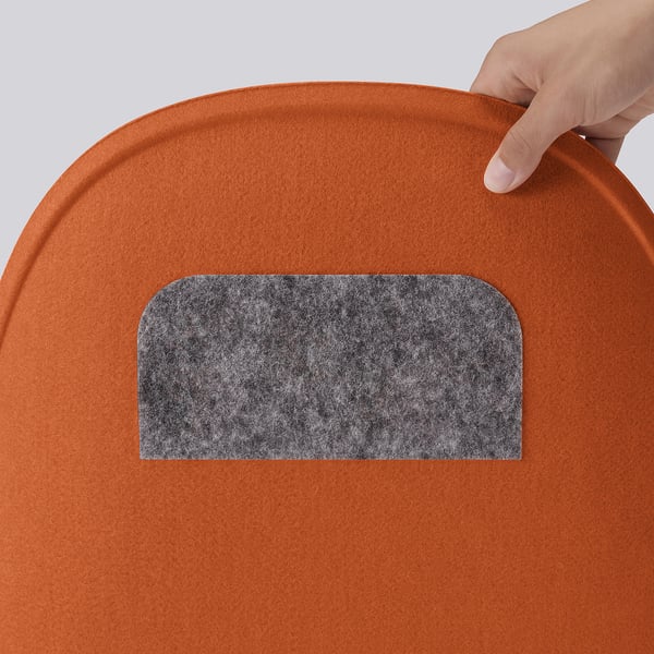 Hand placing orange cushion.