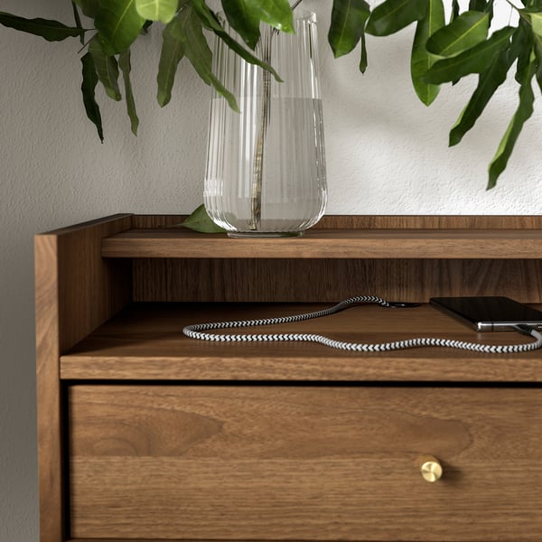 Wooden bedside table with drawer and shelf, featuring a modern design, brass-like knobs, and cable management.
