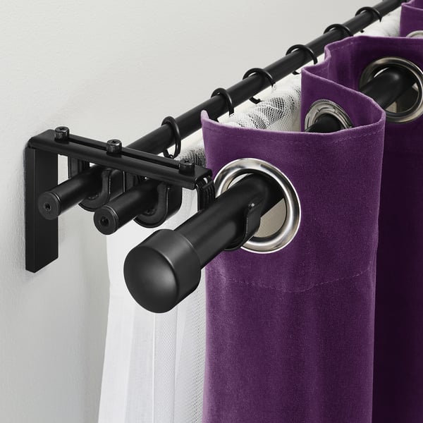 Black curtain rod system with purple curtains and silver rings, showcasing triple rod capability for layered curtains.