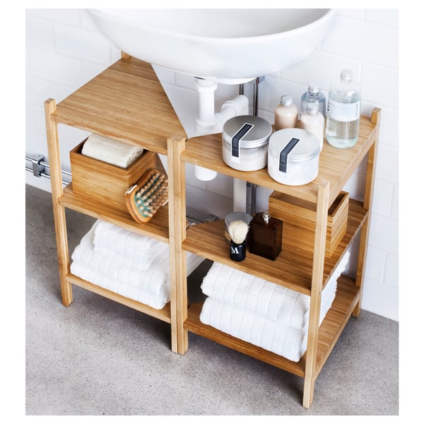 Wooden bathroom storage shelf made of bamboo under a sink. Holds towels, toiletries, and other items.