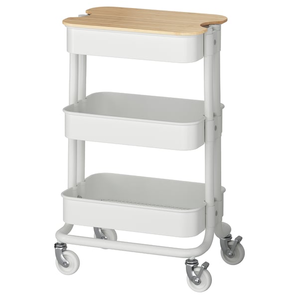 A white RÅSKOG utility cart with three shelves and a bamboo lid top. Its on wheels for easy movement.