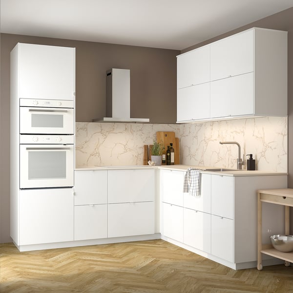 Modern kitchen with white, glossy RINGHULT cabinets. Double oven, hood, marble backsplash, wood floor. Sleek, clean design.