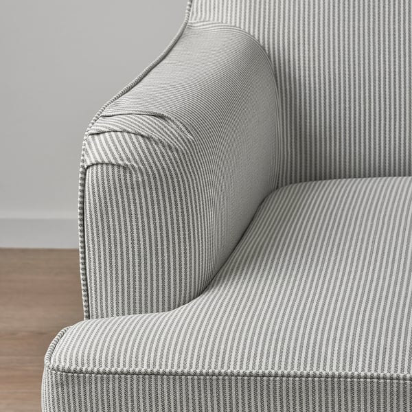 Close-up of striped, textured fabric on a stylish, padded chair with decorative piping and clean lines.