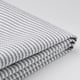 Folded grey and white striped fabric on white surface.