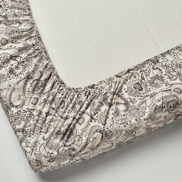 A fitted sheet with classic paisley pattern and elastic edging, designed for mattresses up to 26 cm thick.