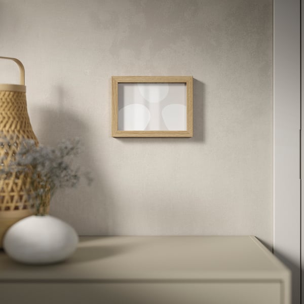 Wooden frame with white circles on grey wall. Vase with blue flowers on beige surface. Horizontal/vertical use.